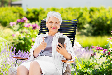 Image showing happy senior woman with phone at summer garden