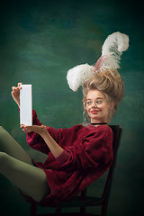 Image showing Young woman as Marie Antoinette on dark background. Retro style, comparison of eras concept.