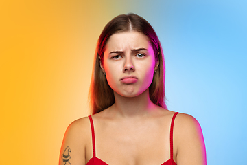 Image showing Caucasian young woman\'s portrait on gradient studio background in neon