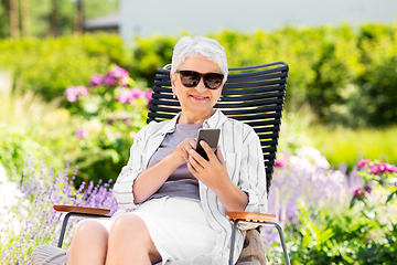 Image showing happy senior woman with phone at summer garden