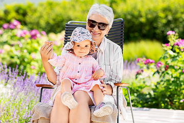 Image showing happy grandmother and baby granddaughter at garden