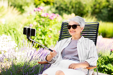 Image showing happy senior woman taking selfie at summer garden