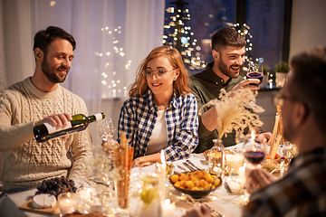 Image showing happy friends with red wine at christmas party