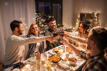 Image showing happy friends drinking red wine at christmas party