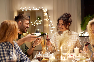 Image showing happy friends with red wine at christmas party