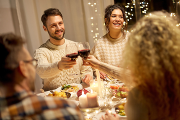 Image showing happy friends drinking red wine at christmas party