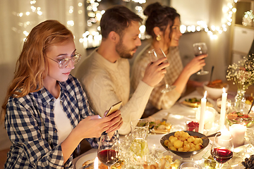 Image showing woman with smartphone at dinner party with friends