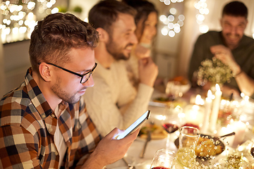 Image showing man with smartphone at dinner party with friends