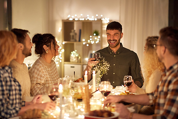 Image showing happy friends drinking red wine at christmas party