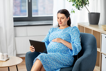 Image showing happy pregnant woman with tablet pc at home