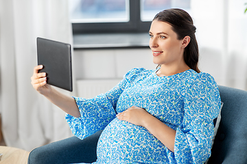 Image showing happy pregnant woman with tablet pc at home