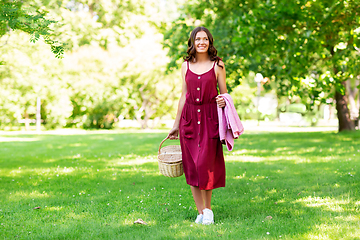 Image showing happy woman with picnic basket and blanket at park