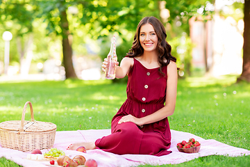 Image showing happy woman with picnic basket and drink at park