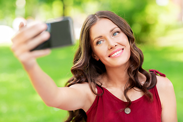 Image showing happy woman with smartphone taking selfie at park