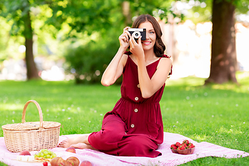 Image showing happy woman with camera on picnic at park