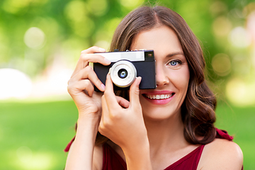 Image showing happy woman with camera photographing at park