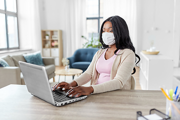 Image showing woman in mask with laptop working at home office