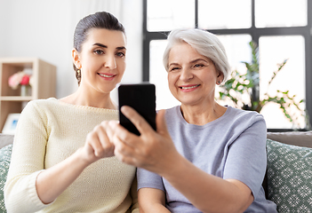 Image showing daughter and senior mother with smartphone at home