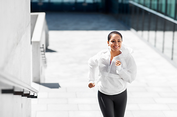 Image showing african american woman running upstairs outdoors