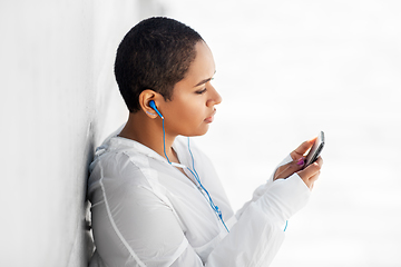 Image showing african american woman with earphones and phone