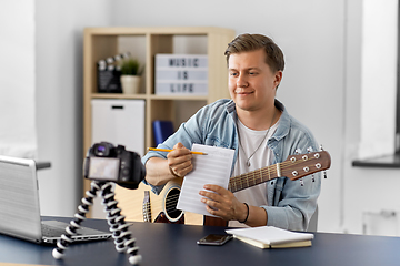 Image showing man or blogger with camera, music book and guitar