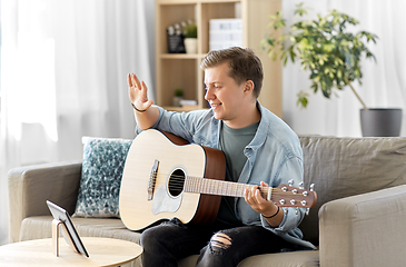 Image showing man with tablet pc and guitar having video call