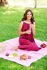 Image showing happy woman with picnic basket and drink at park