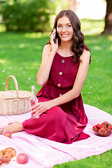 Image showing woman calling on smartphone on picnic at park