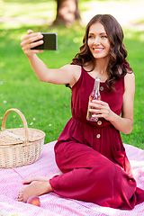 Image showing happy woman with smartphone taking selfie at park