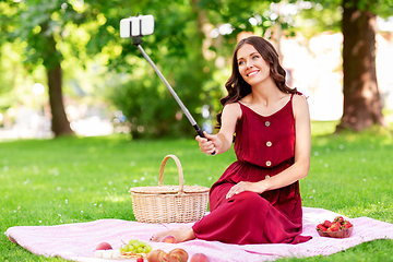 Image showing happy woman with smartphone taking selfie at park