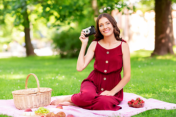 Image showing happy woman with camera on picnic at park