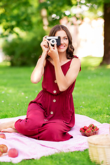 Image showing happy woman with camera on picnic at park