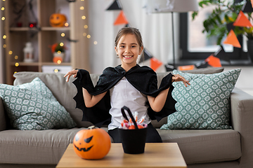 Image showing girl in halloween costume with bat cape at home