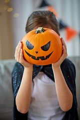 Image showing girl in halloween costume with pumpkin at home