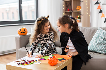 Image showing girls in halloween costumes doing crafts at home