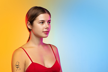 Image showing Caucasian young woman\'s portrait on gradient studio background in neon