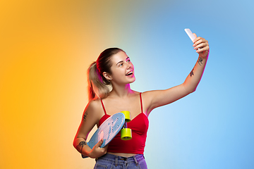 Image showing Caucasian young woman\'s portrait on gradient studio background in neon