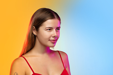 Image showing Caucasian young woman\'s portrait on gradient studio background in neon