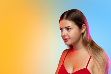 Image showing Caucasian young woman\'s portrait on gradient studio background in neon