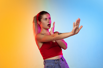 Image showing Caucasian young woman\'s portrait on gradient studio background in neon