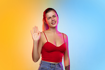 Image showing Caucasian young woman\'s portrait on gradient studio background in neon