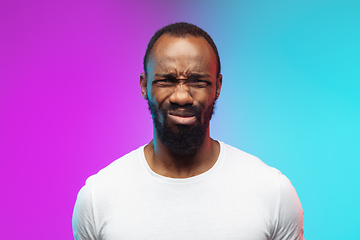 Image showing African-american young man\'s portrait on gradient studio background in neon, close up