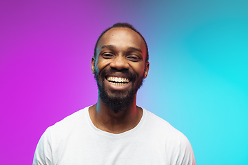 Image showing African-american young man\'s portrait on gradient studio background in neon, close up