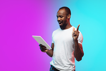 Image showing African-american young man\'s portrait on gradient studio background in neon