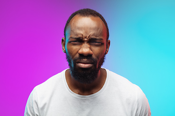 Image showing African-american young man\'s portrait on gradient studio background in neon, close up