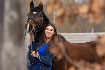 Image showing Portrait of a happy beautiful girl of Slavic appearance and a horse