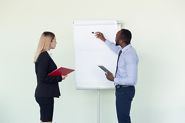 Image showing Young businessman working with colleague using flipchart, copyspace