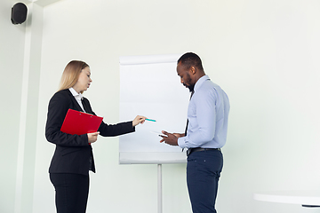 Image showing Young businessman working with colleague using flipchart, copyspace