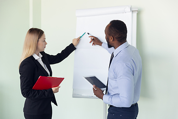 Image showing Young businessman working with colleague using flipchart, copyspace