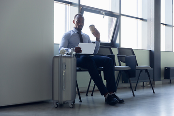 Image showing Young businessman waiting for departure in airport, work trip, business lifestyle